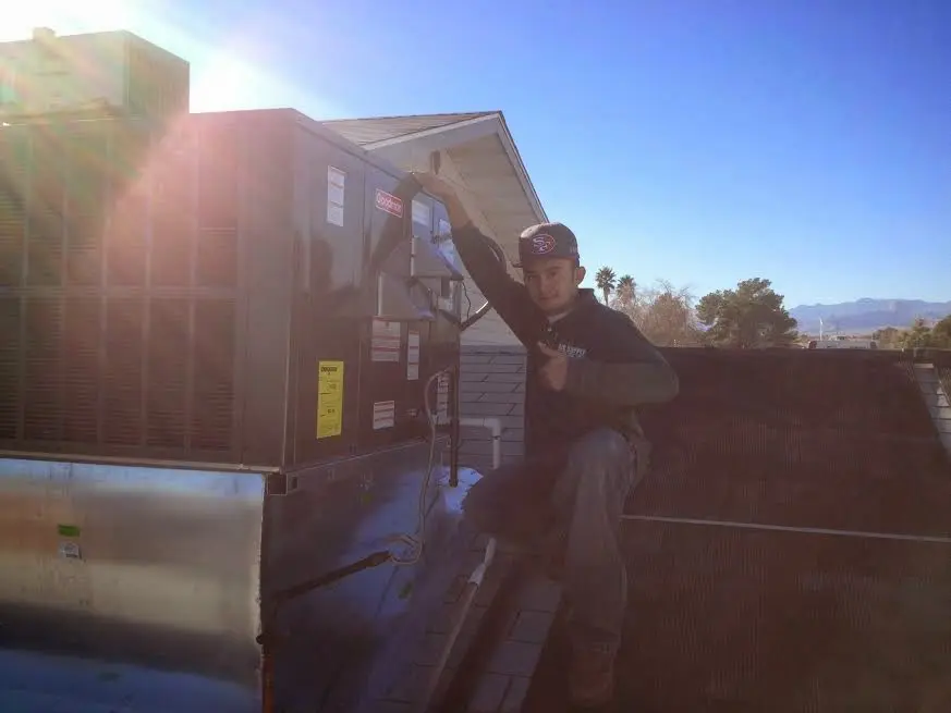 HVAC technician performing HVAC Inspection on a rooftop unit in Middlebury